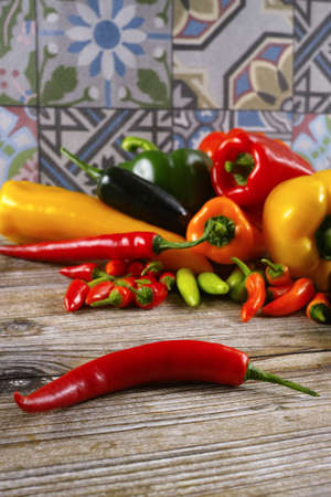 Mexican hot chili peppers colorful mix paprika poblano serrano jalapeno on ornamental and wooden backgroundの写真素材