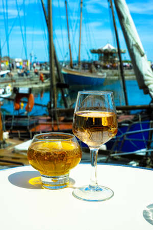 Normandy apple cider in traditional glass and rose vine in old French fisherman village