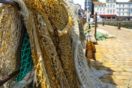 Fisherman's nets and old iron chain in old French harborの写真素材