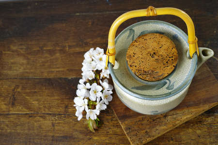 Japan's teapot with sakura flowers on dark wooden backgroundの写真素材