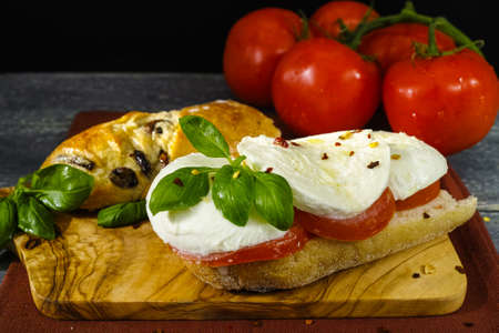 Healthy Vegetarian Veggie Sandwich with tomato, basil, mozzarella cheese made with bread with black...