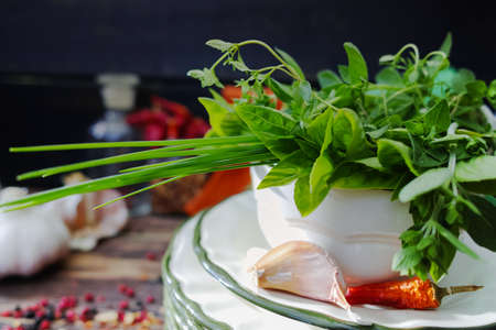 Fresh  italian herbs, garlic, dried red hot chili peppers, taditional italian dishes on old wooden backgroundの写真素材