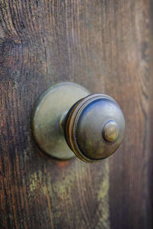 Old ancient door knocker on wooden door, Tuscany, Italyの写真素材