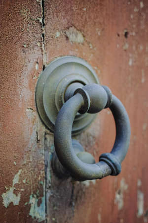 Old ancient door knocker on wooden door, Tuscany, Italyの写真素材