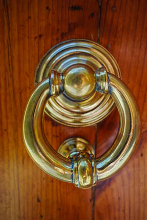 Old ancient door knocker on wooden door, Tuscany, Italy