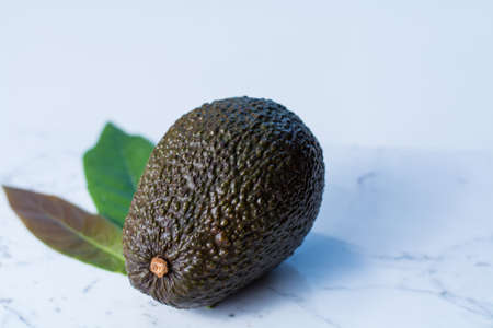 Green ripe avocado on white marble backgroundの写真素材