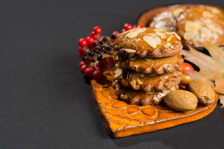 Typical Dutch filled spicy  cookies with almonds on autumn colored and dark backgroundの写真素材