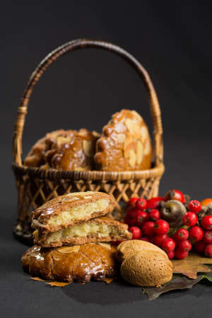 Typical Dutch filled spicy  cookies with almonds on autumn colored and dark backgroundの写真素材