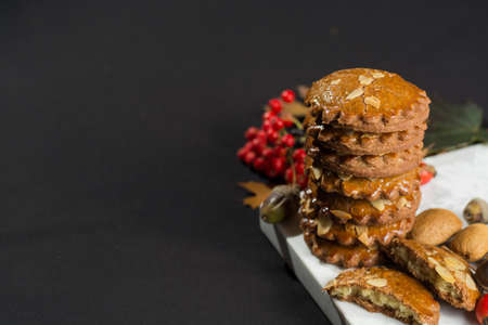 Typical Dutch filled spicy  cookies with almonds on autumn colored and dark backgroundの写真素材