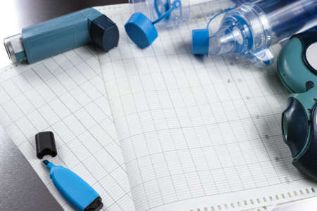 Asthma relief concept, salbutamol inhalers, aerosol medication and paper on chrome background