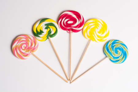 Multicolored sweet candy canes on wooden sticks, variety