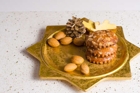 Christmas cookies with almond nuts and ginger on golden plate, holiday conceptの写真素材