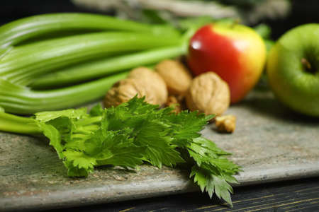Ingredients for Waldorf salad -  celery, apples, walnotes - fresh and healthy vegetables on granite...