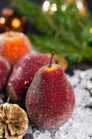Christmas decoration, close up, apples and pears on white iceの写真素材