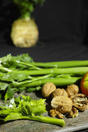 Ingredients for Waldorf salad -  celery, apples, walnotes - fresh and healthy vegetables on granite board.の写真素材