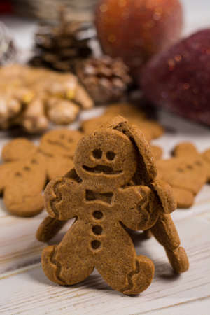 Christmas smiling  gingerbread men, men and women  on rustic wooden background