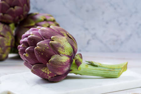 Fresh big Romanesco artichokes green-purple flower heads ready to cook seasonal foodの写真素材