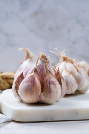 Garlic. Dried French garlic. Red garlic. Violet garlic.Garlic background. garlic bulbs on white marble.の写真素材
