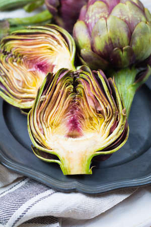Fresh big Romanesco artichokes green-purple flower heads ready to cook seasonal foodの写真素材