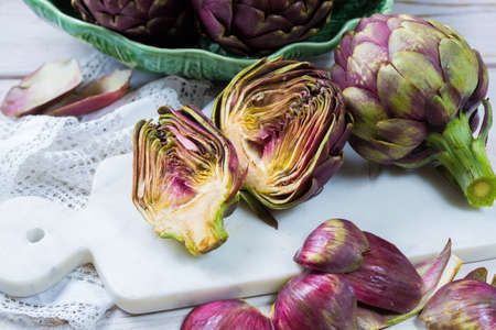 Fresh big Romanesco artichokes green-purple flower heads ready to cook seasonal foodの写真素材
