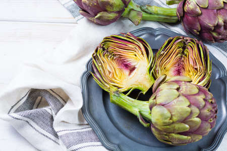 Fresh big Romanesco artichokes green-purple flower heads ready to cook seasonal foodの写真素材