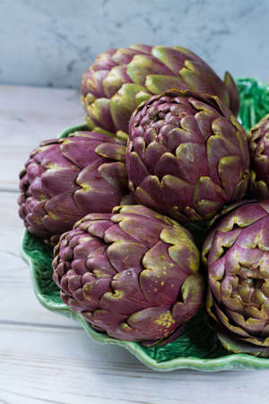 Fresh big Romanesco artichokes green-purple flower heads ready to cook seasonal foodの写真素材