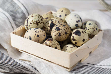 Small quail eggs in wooden box, Easter concept, diet mealの写真素材