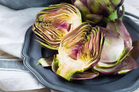 Fresh big Romanesco artichokes green-purple flower heads ready to cook seasonal foodの写真素材