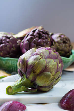 Fresh big Romanesco artichokes green-purple flower heads ready to cook seasonal foodの写真素材