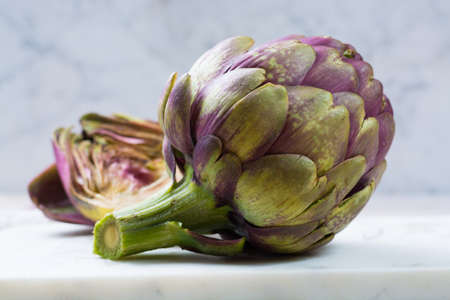 Fresh big Romanesco artichokes green-purple flower heads ready to cook seasonal foodの写真素材