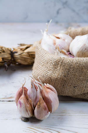 Garlic. Dried French garlic. Red garlic. Violet garlic.Garlic background. garlic bulbs on white marble.の写真素材