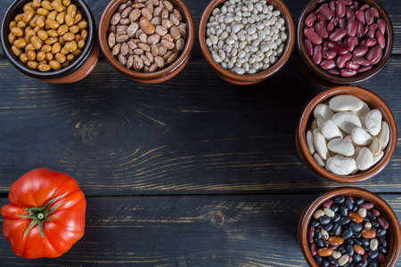Assortment of beans on black wooden background. Soybean, red kidney bean, black bean,white bean, red bean and brown pinto beansの写真素材