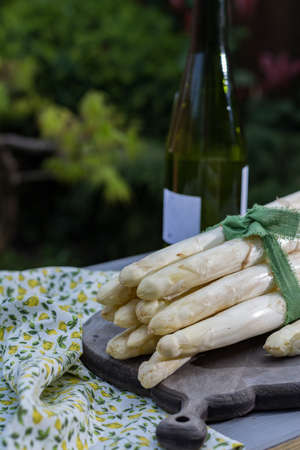Spring food - fresh white big asparagus ready to cook on the table outside and garden view, sunny dayの写真素材