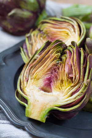 Fresh big Romanesco artichokes green-purple flower heads ready to cook seasonal foodの写真素材