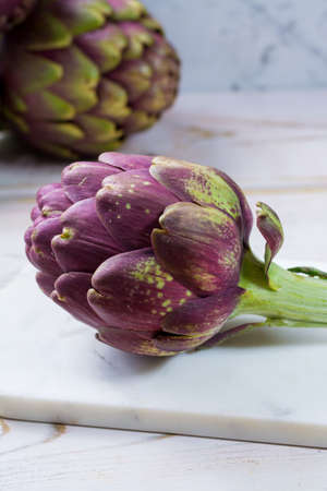Fresh big Romanesco artichokes green-purple flower heads ready to cook seasonal foodの写真素材