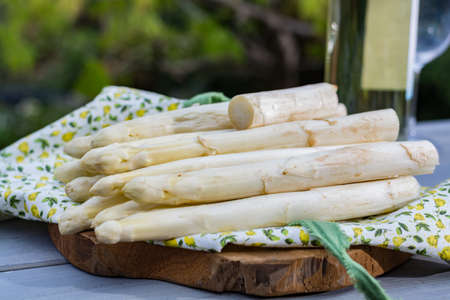 Spring food - fresh white big asparagus ready to cook on the table outside and garden view, sunny dayの写真素材