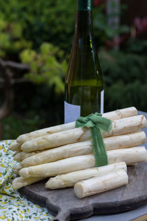 Spring food - fresh white big asparagus ready to cook on the table outside and garden view, sunny dayの写真素材