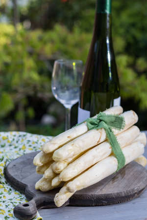 Spring food - fresh white big asparagus ready to cook on the table outside and garden view, sunny dayの写真素材
