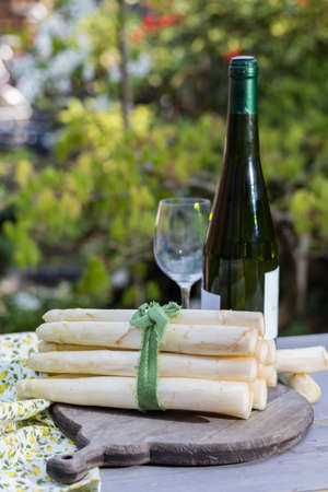 Spring food - fresh white big asparagus ready to cook on the table outside and garden view, sunny dayの写真素材