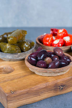 Mediterranean appetizer antipasti tapas bowls with green and calamata olives, feta cheese, stuffed pepper, herbsの写真素材