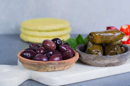 Mediterranean appetizer antipasti tapas bowls with green and calamata olives, feta cheese, stuffed pepper, herbsの写真素材