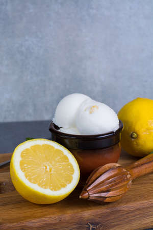 Lemon ice cream sorbet served for dessert on wooden plank in small bowlの写真素材