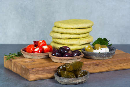 Mediterranean appetizer antipasti tapas bowls with green and calamata olives, feta cheese, stuffed pepper, herbsの写真素材