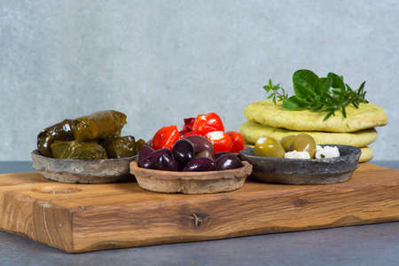 Mediterranean appetizer antipasti tapas bowls with green and calamata olives, feta cheese, stuffed pepper, herbsの写真素材