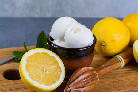 Lemon ice cream sorbet served for dessert on wooden plank in small bowlの写真素材