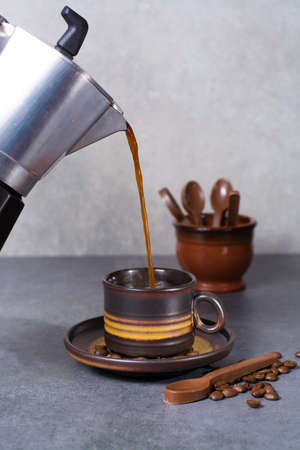 Black arabica coffee cup and roasted coffee beans on grey backgroundの写真素材