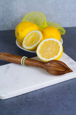 Ripe juicy yellow lemons witn juicer stick made from olive tree woodの写真素材