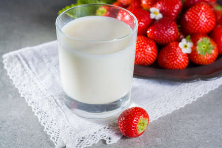 Fresh cow milk and ripe organic strawberry on grey background copy spaceの写真素材