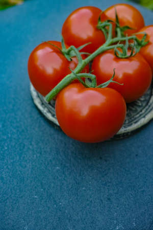 Fresh red ripe tomatoes  on black stone in the gardenの写真素材