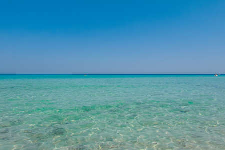 Crystal clear sea water texture with glare from the sunの写真素材